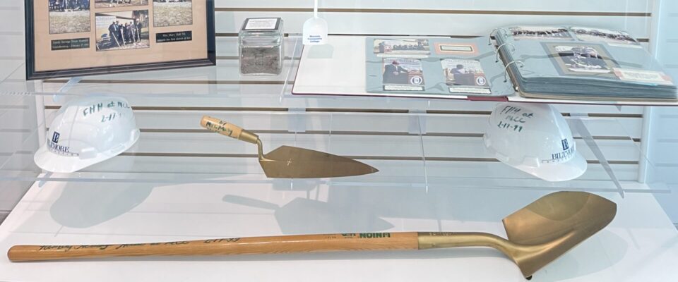 Display case with a gold shovel and groundbreaking photos