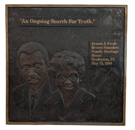Plaque with the faces of Mr and Mrs Brown and a quote